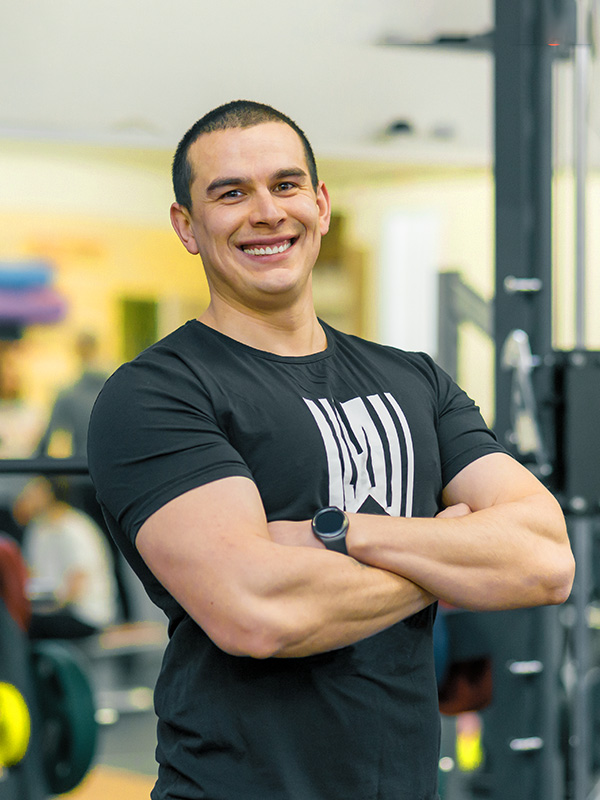 portrait-of-muscular-sporty-smiling-man-in-the-gym-SKGJ3DM.jpg